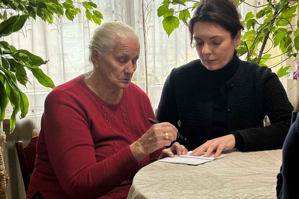 Alina, born in 1932 in Pełczyn. Alina sketches a map for a Yahad Investigator/Educator. We would later go to the mass grave that Alina placed on the map. She also described a second mass grave near the first that has not been completely confirmed yet. Taken in her home on November 28 in Pełczyn. ©Todd Hennessy/Yahad-In Unum